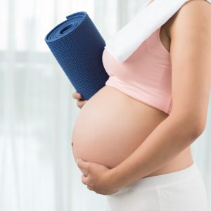 Active and sporty pregnancy Cropped image of sporty pregnant woman with yoga mat
