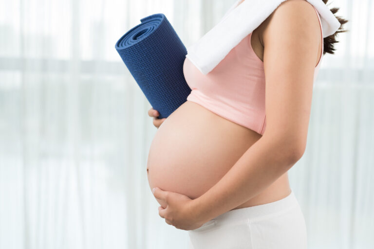 Active and sporty pregnancy Cropped image of sporty pregnant woman with yoga mat