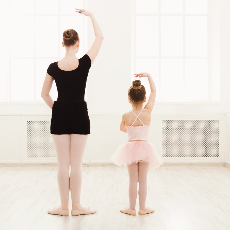 Little girl learn ballet with teacher copy space Little girl learning ballet with teacher copy space. Cute small ballerina training classical dance exercises with female coach, back view